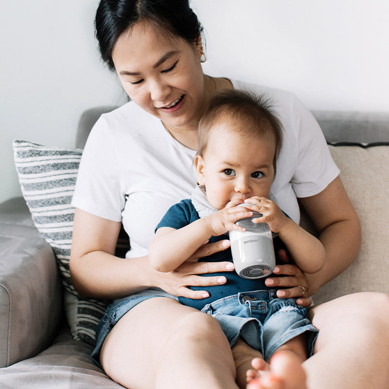 Parent Holds the Ember Baby Bottle filled with milk.