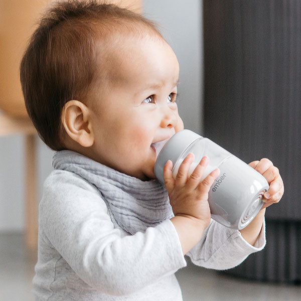 Parent Holds the Ember Baby Bottle filled with milk.